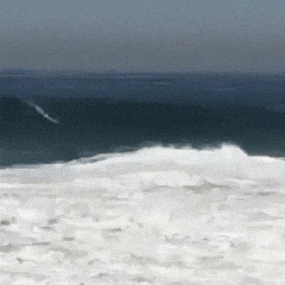 A surfer gets tossed like a rag doll from a large wave