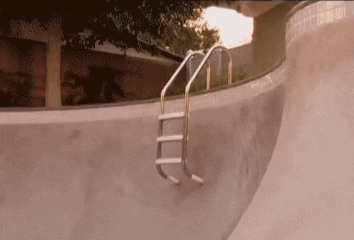 A skateboarder jumps over a pool ladder